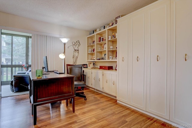 office space with a textured ceiling and light wood-type flooring