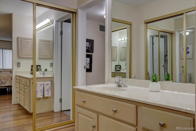 bathroom featuring wood-type flooring, vanity, and a textured ceiling