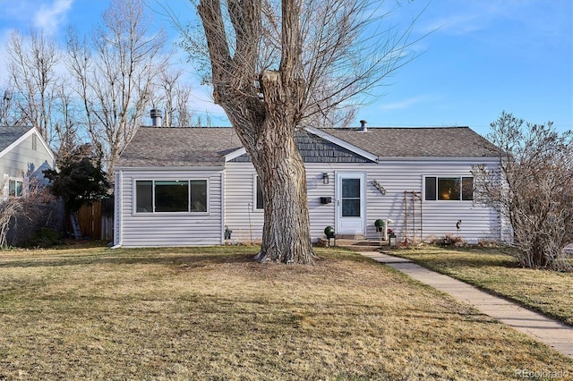 ranch-style house with a front lawn and a shingled roof