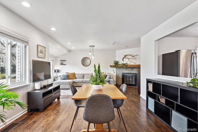 dining area with a glass covered fireplace, recessed lighting, dark wood-style floors, and baseboards