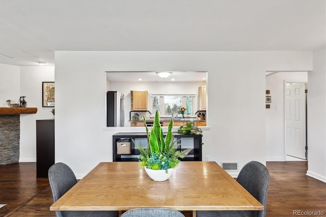 dining area with visible vents, baseboards, and dark wood-style flooring