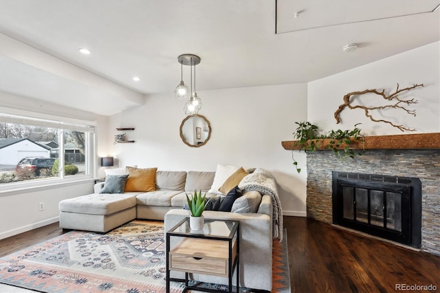 living room featuring recessed lighting, baseboards, a stone fireplace, and wood finished floors