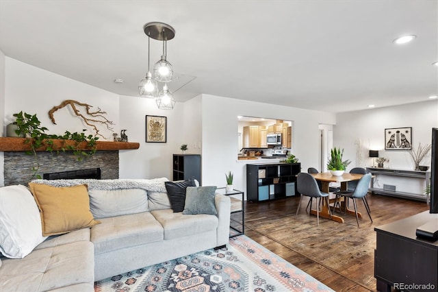 living room with dark wood-style floors, recessed lighting, and a fireplace