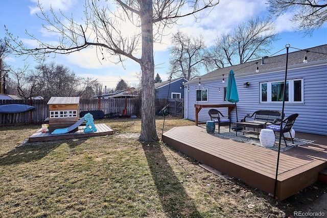 view of yard with a deck, an outdoor hangout area, a playground, and a fenced backyard