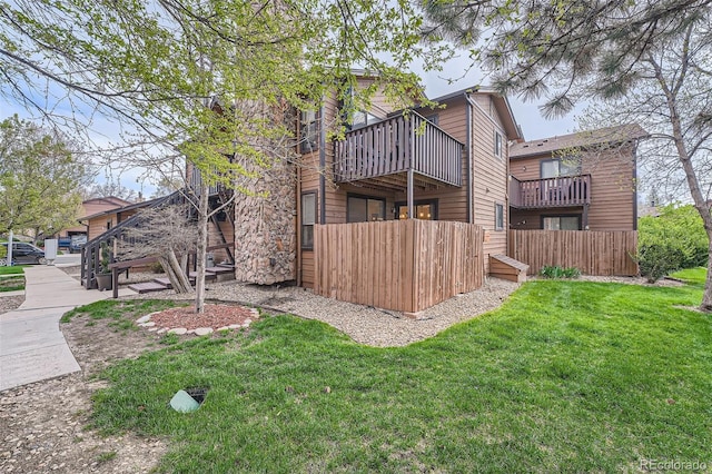 back of property with fence and a lawn