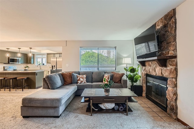 tiled living area with a fireplace and a sink