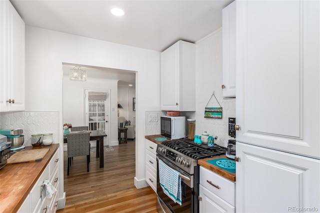 1160 S Monroe St, Denver, CO 80210 - kitchen featuring white cabinetry, wooden counters, light wood-style floors, decorative backsplash, and stainless steel gas stove