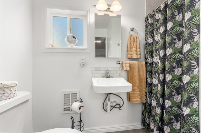 1160 S Monroe St, Denver, CO 80210 - full bath with visible vents, curtained shower, a sink, toilet, and backsplash