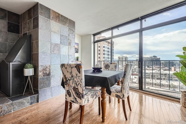 dining room with a view of city, expansive windows, and hardwood / wood-style floors