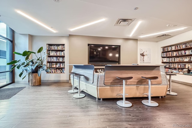 bar featuring built in shelves, baseboards, wood finished floors, and visible vents