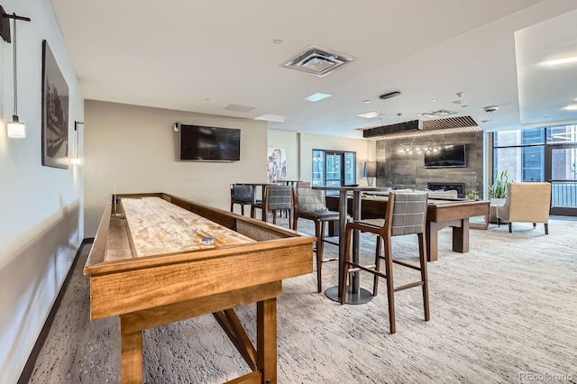 recreation room featuring baseboards, a fireplace, and visible vents