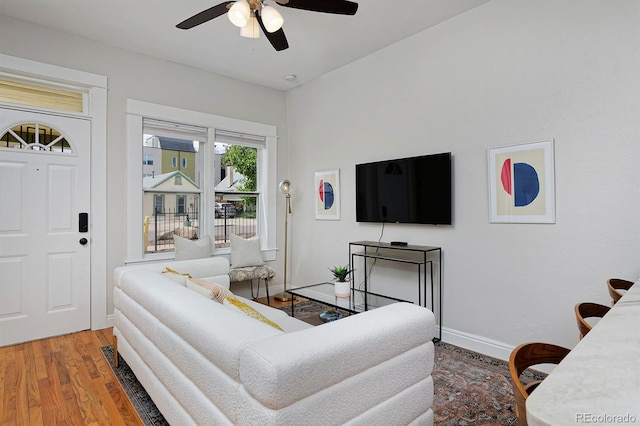 living area with ceiling fan, wood finished floors, and baseboards