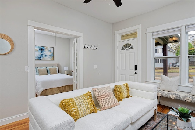 living room with ceiling fan, wood finished floors, and baseboards