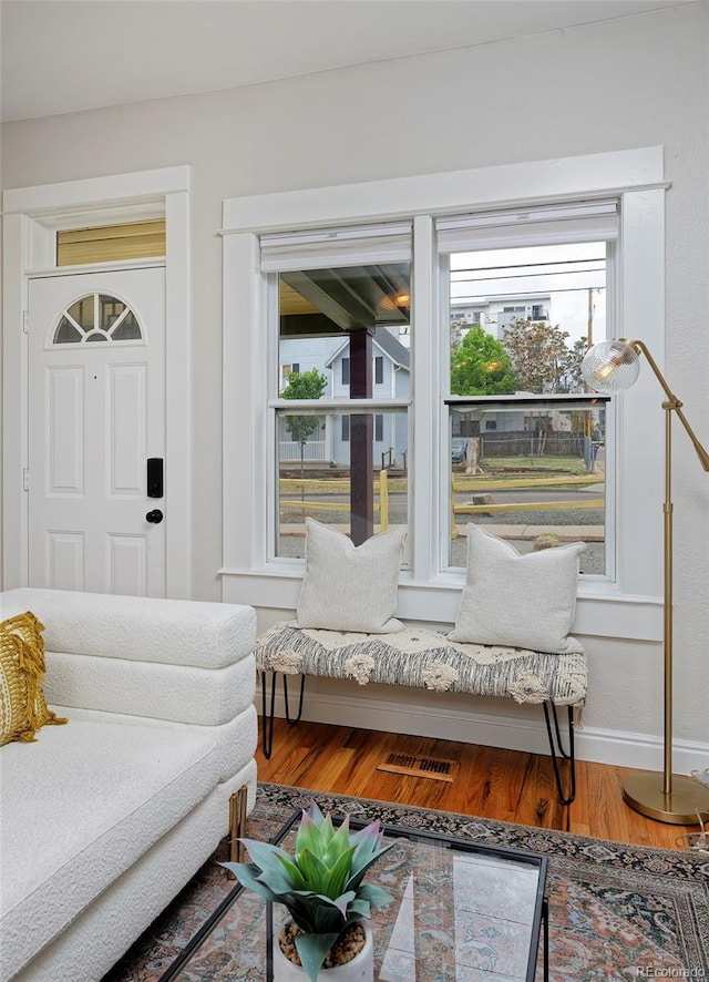 living room featuring healthy amount of natural light, wood finished floors, and baseboards