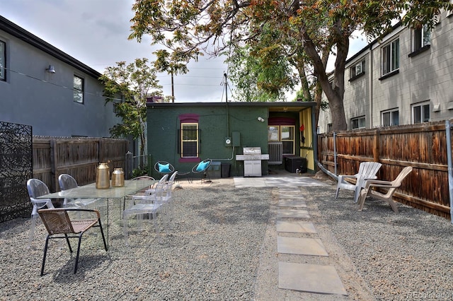 rear view of property featuring a fenced backyard, a patio area, and outdoor dining space