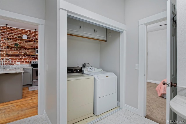 2424 N Clay St, Denver, CO 80211 - laundry room with washer and clothes dryer, cabinet space, light tile patterned floors, and baseboards