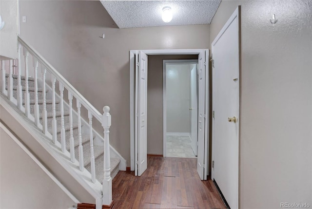 hallway featuring a textured ceiling and dark hardwood / wood-style flooring