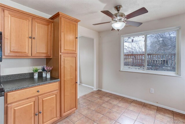 kitchen featuring light tile patterned floors, a textured ceiling, and ceiling fan