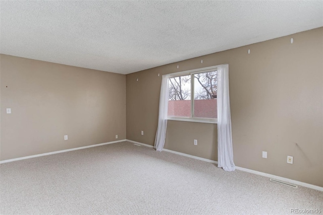 carpeted spare room with a textured ceiling