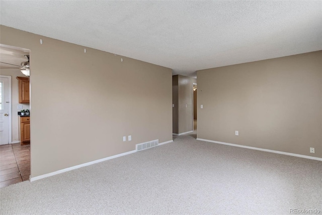 unfurnished room with ceiling fan, carpet floors, and a textured ceiling