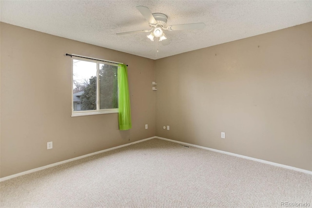 carpeted spare room featuring ceiling fan and a textured ceiling