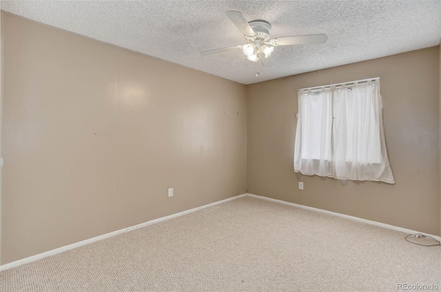 carpeted empty room featuring ceiling fan and a textured ceiling