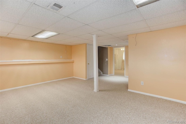 basement with carpet floors and a paneled ceiling