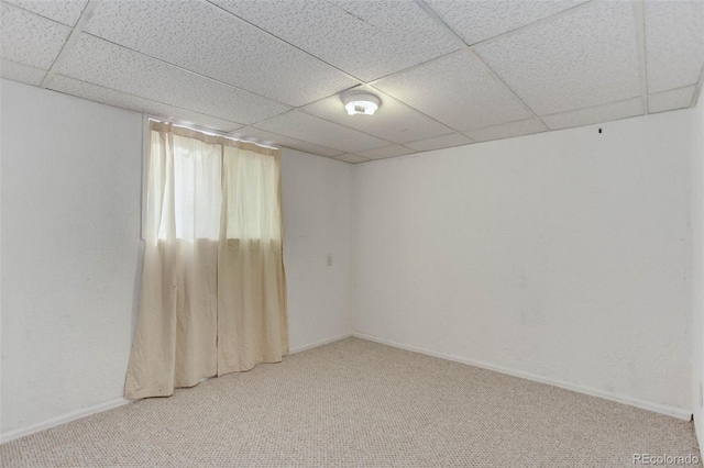 carpeted spare room featuring a drop ceiling