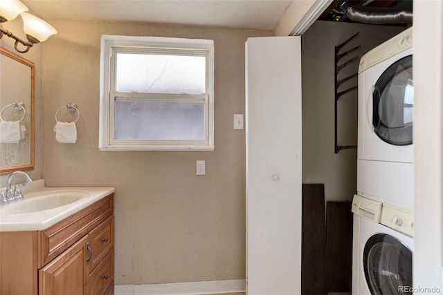 clothes washing area featuring stacked washer and dryer and sink