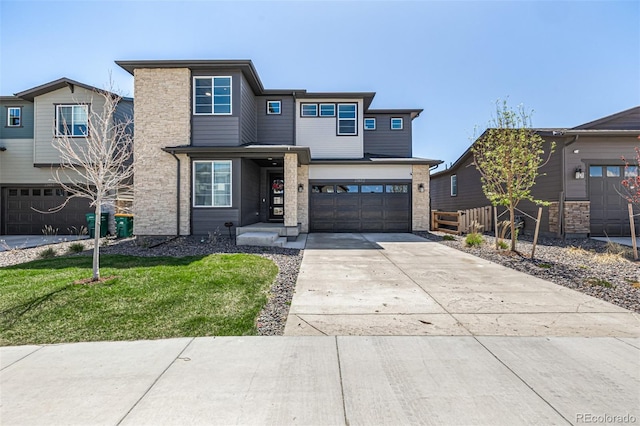 prairie-style home featuring a garage, a front yard, stone siding, and concrete driveway
