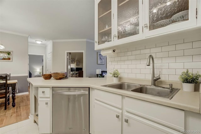 kitchen featuring light countertops, white cabinets, a sink, dishwasher, and a peninsula