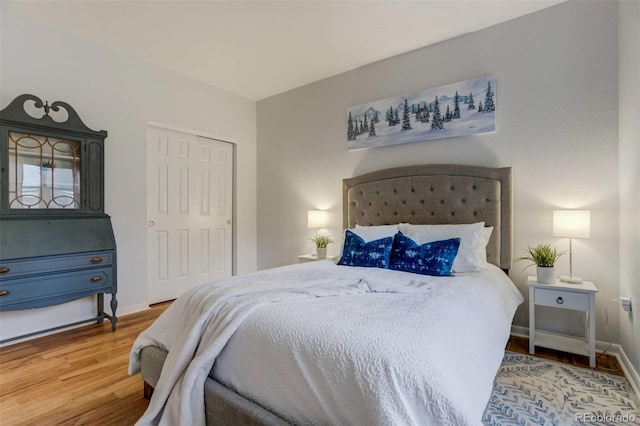 bedroom featuring a closet, wood finished floors, and baseboards