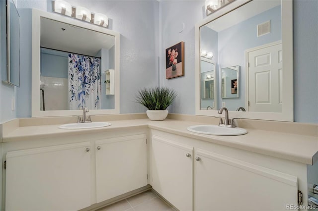 bathroom featuring double vanity, visible vents, a sink, and tile patterned floors