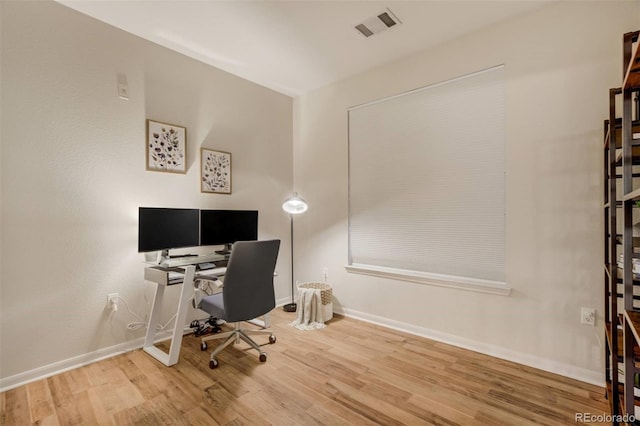 home office featuring visible vents, baseboards, and wood finished floors