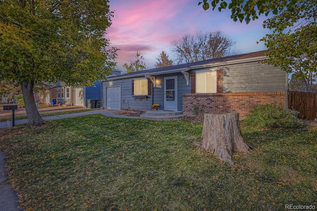 single story home featuring a yard and a garage