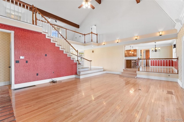 6231 Prospect Rd, Longmont, CO 80503 - unfurnished living room featuring wallpapered walls, wood finished floors, a chandelier, stairway, and a ceiling fan