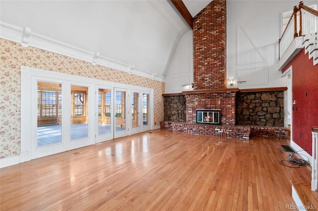 6231 Prospect Rd, Longmont, CO 80503 - unfurnished living room with high vaulted ceiling, light wood finished floors, wallpapered walls, healthy amount of natural light, and a brick fireplace