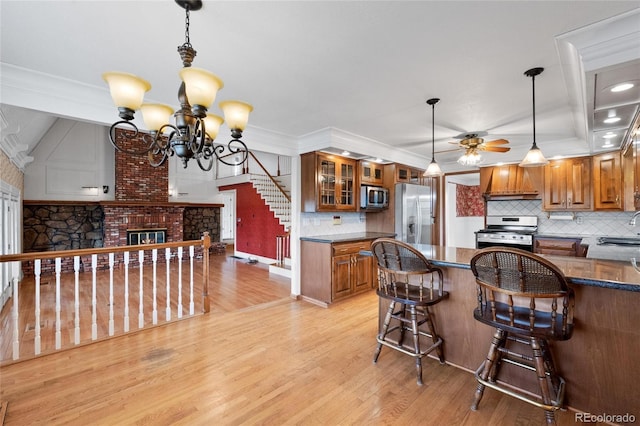6231 Prospect Rd, Longmont, CO 80503 - kitchen featuring stainless steel appliances, brown cabinetry, tasteful backsplash, light wood-type flooring, and crown molding