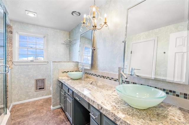 6231 Prospect Rd, Longmont, CO 80503 - full bathroom featuring a chandelier, a shower stall, double vanity, baseboards, and wallpapered walls