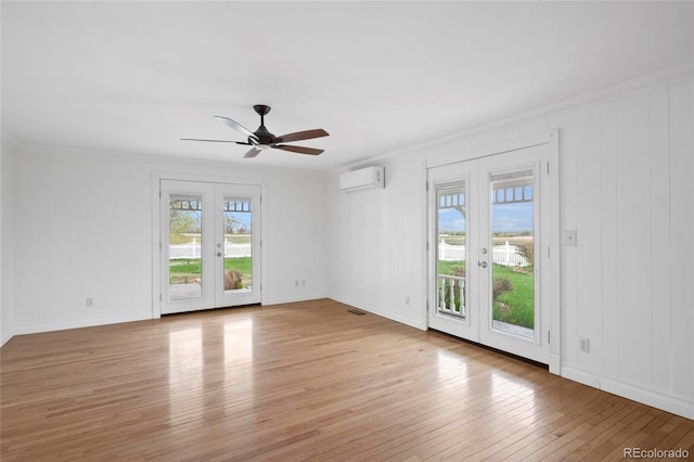 6231 Prospect Rd, Longmont, CO 80503 - unfurnished room with french doors, a wall unit AC, light wood finished floors, a ceiling fan, and crown molding