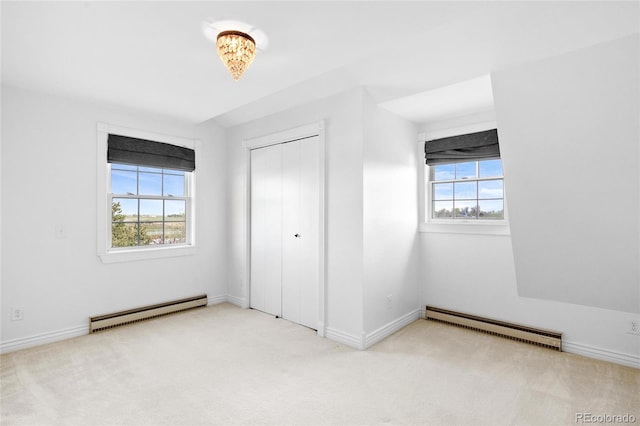 6231 Prospect Rd, Longmont, CO 80503 - unfurnished bedroom featuring a baseboard heating unit, multiple windows, and carpet flooring