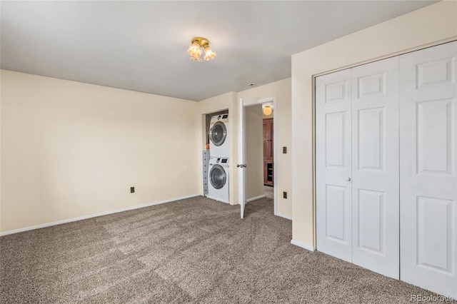 6231 Prospect Rd, Longmont, CO 80503 - unfurnished bedroom featuring stacked washing machine and dryer, carpet, baseboards, and a closet