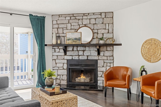 8335 Fairmount Dr Unit 208, Denver, CO 80247 - living area featuring wood finished floors, healthy amount of natural light, and a stone fireplace