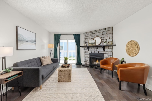 8335 Fairmount Dr Unit 208, Denver, CO 80247 - living area featuring a textured ceiling, wood finished floors, and a fireplace