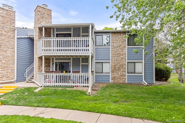 8335 Fairmount Dr Unit 208, Denver, CO 80247 - view of front facade featuring a front yard, stone siding, a porch, and a sunroom