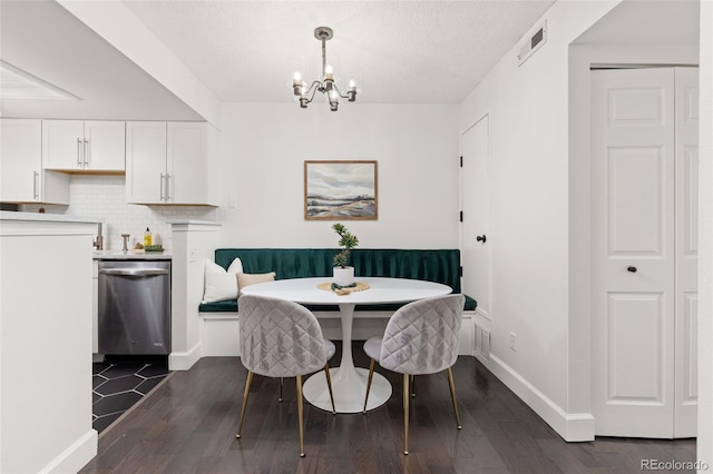 8335 Fairmount Dr Unit 208, Denver, CO 80247 - dining area with breakfast area, dark wood-style floors, a chandelier, and a textured ceiling