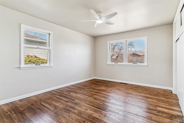 unfurnished bedroom featuring multiple windows, wood finished floors, and visible vents