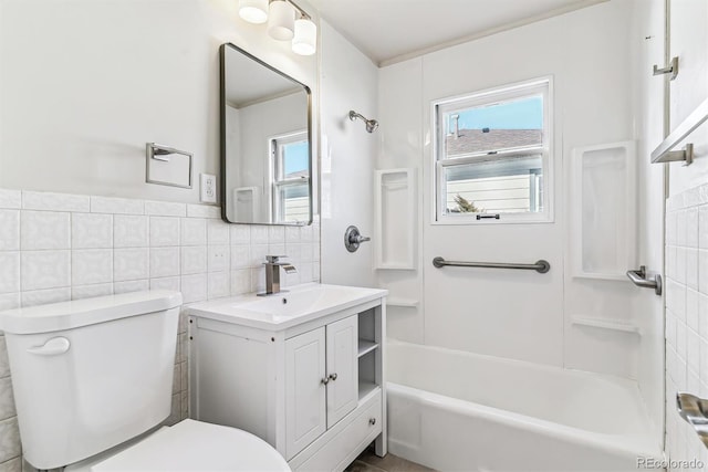 full bathroom featuring bathing tub / shower combination, vanity, toilet, and tile walls