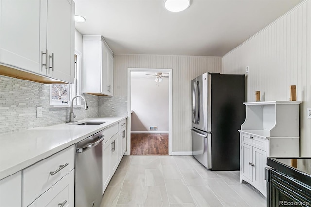 kitchen with white cabinets, appliances with stainless steel finishes, light countertops, and a sink