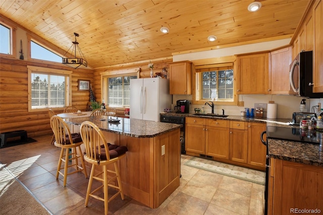 kitchen featuring sink, white refrigerator, decorative light fixtures, a kitchen island, and wood ceiling